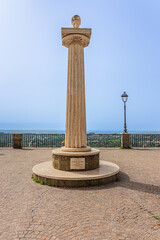 Travertine column with sculpture in memory of Giuseppe Mazzini, in the homonymous square with panoramic terrace. Ariccia, Lazio, Italy