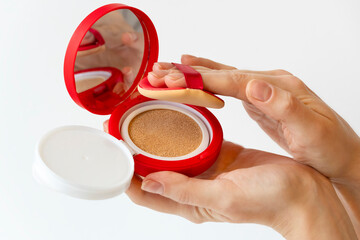 Woman hands with cushion foundation in red package, makeup beauty product liquid foundation, korean skincare tonal foundation