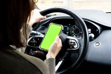 Close-up of woman's hands holding smartphone with green empty copy space on screen mockup behind...