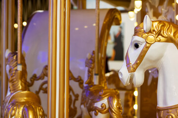 A beautifully designed merrygoround featuring gold and white horses