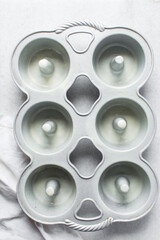 overhead view of silver bundtlette pan, flatlay of six cavity mini bundt pan, top view of cast iron baking pan