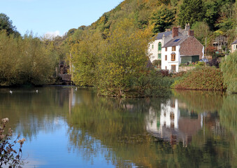 Fototapeta premium View across Cromford Mill pond towards the mill waterwheel, Derbyshire England 