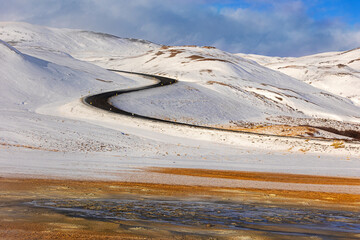 A curvy road over Mt. Namafjall with Hverir geothermal ground in foreground