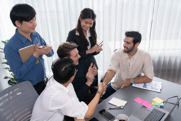 Diverse group of office employee worker shake hand after making agreement on strategic business marketing meeting. Teamwork and positive attitude create productive and supportive workplace. Prudent