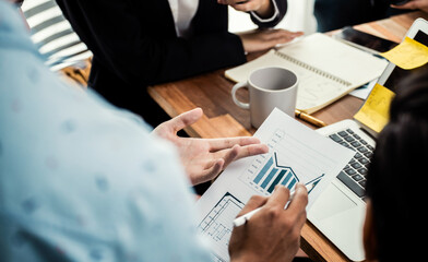 Diverse group of business analyst team analyzing financial data report paper on office table. Chart and graph dashboard by business intelligence analysis for strategic marketing planning Meticulous