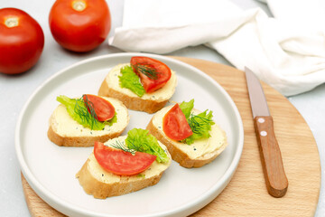 Bruschetta sandwich bread toast with cheese ricotta,fresh tomatoes,basil greenery on cutting board.Tasty healthy vegetarian food,Italian cuisine appetizer
