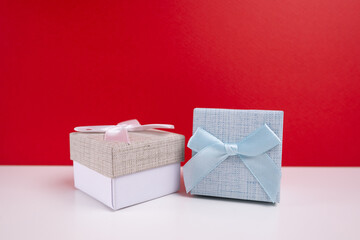 Stylish gift boxes with bow on color background. Valentines day gift for him. Corporate gift...