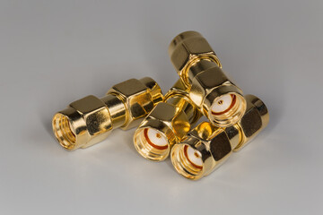 High-frequency yellow straight coaxial adapters on a gray surface