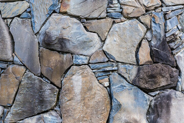 Wall built with natural stones different sizes in overcast day