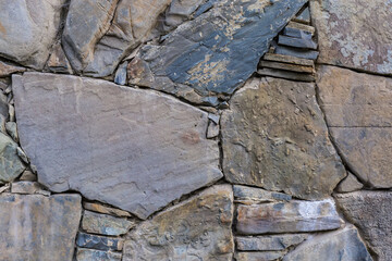 Wall of natural flat stones different sizes in overcast day