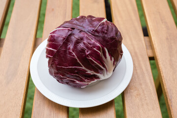 Head of radicchio on white dish on a wooden table