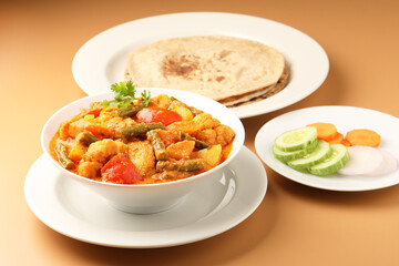Mix vegetable curry - Indian main course recipe contains Carrots, cauliflower, green peas and beans and served in ceramic ware with Chapati ,Indian flat bread , roti