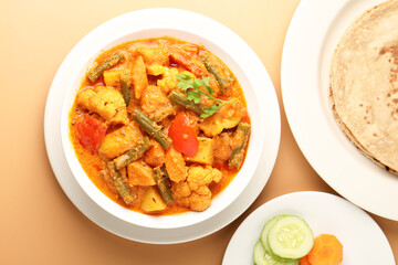 Mix vegetable curry - Indian main course recipe contains Carrots, cauliflower, green peas and beans and served in ceramic ware with Chapati ,Indian flat bread , roti