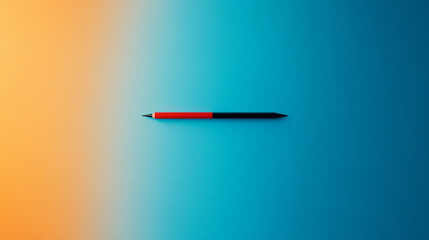Fototapeta premium A single red and black pen lays flat on a blue and yellow gradient background.