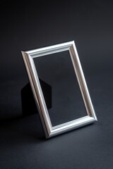 Fototapeta premium A silver picture frame sits on a dark surface, ready to hold a cherished memory.
