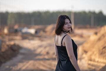 Portrait of a young beautiful dark-haired girl in summer clothes in an urban environment.