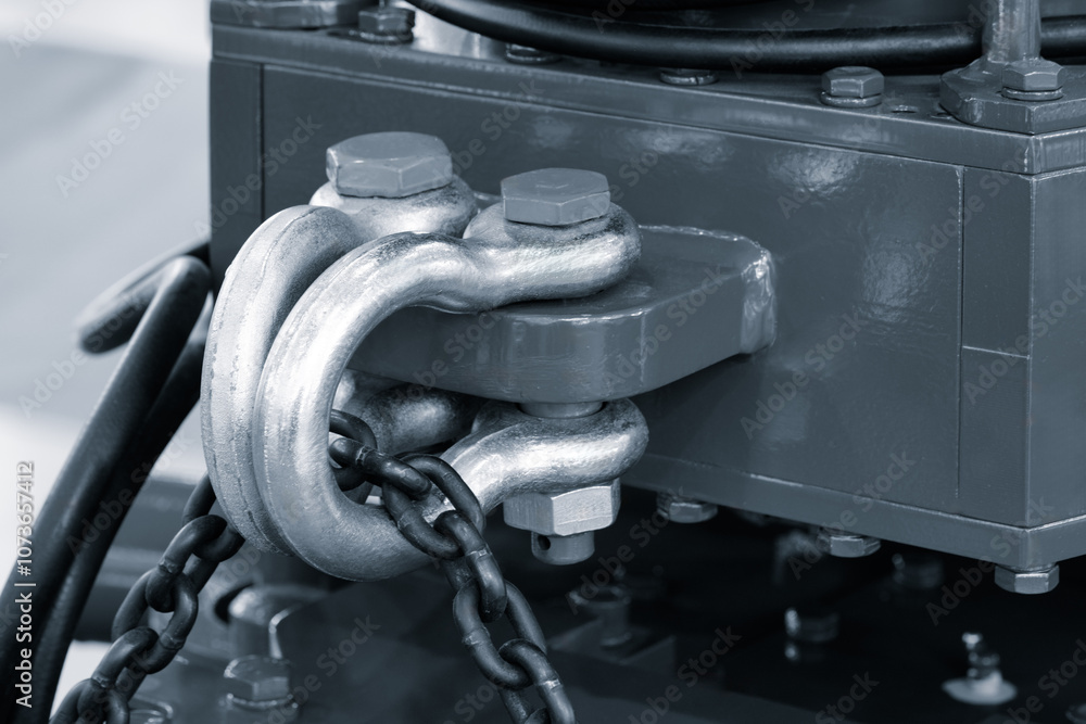 Poster A chain is connected to a metal object with a bolt. The chain is attached to the object with a metal hook