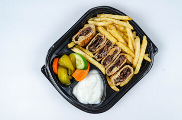 Close up of chicken shawarma meal with lettuce, tomato and onion on white background.
