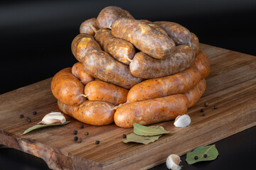 A Variety of Delicious Assorted Sausages Arranged on a Wooden Board with Herbs and Spices