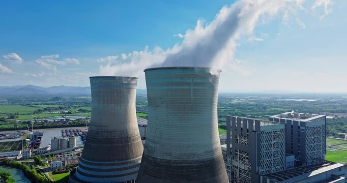 Steam rises from the huge chimneys of the operating power plant. Business Finance and Industry