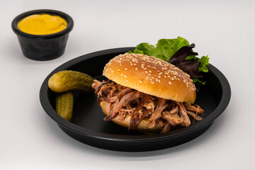 Delicious Pulled Pork Sandwich topped with Crunchy Pickles and Tangy Mustard Sauce