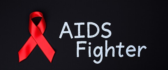 AIDS Awareness Concept by Red Ribbon with “AIDS Fighter” text on black background.