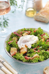 A bowl with salad lyonnaise served for lunch