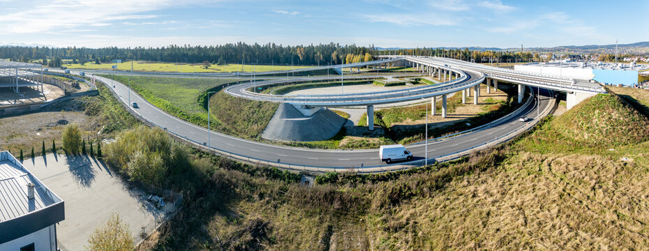 Nowy Trag, Poland. End of new Zakopinaka Highway under construction but opened for traffic. Exit rams to old road to Zakopane and Nowy Targ center. Aerial wide drone panorama. State in October 2024