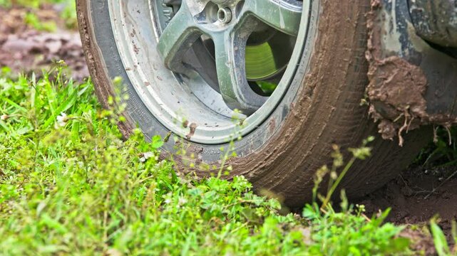car tire slipping while stuck in a dirt, heating up and steaming in attempt to get free, closeup with selective focus