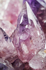 Vertical close-up shot of pink and purple crystals and gemstones. Brilliant glowing diamond design.