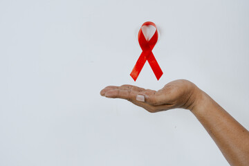AIDS ribbon in hand isolated on white background.