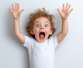 Excited child with curly hair expressing joy against a plain background indoors