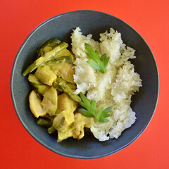 Chicken Thai green curry with white rice in a bowl.