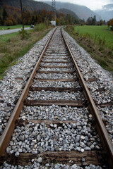 Fototapeta premium Railroad tracks disappearing into the mountainous landscape. Train lines outdoors. Public transportation