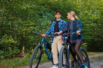 Naklejka premium A young man and a woman during a bike ride in nature