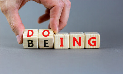 Doing or being symbol. Concept word Doing and Being on wooden cubes. Businessman hand. Beautiful...