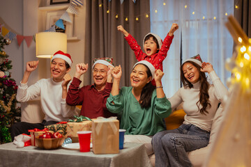 christmas, merry christmas, party, parenthood, celebrate, enjoyment, present, celebration, family, enjoying. A family is gathered around a table. They are all wearing festive hats and are smiling.