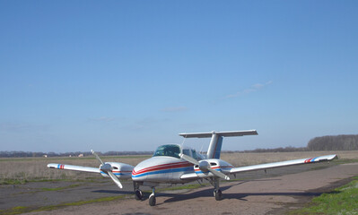 A twin-engine propeller plane is on the ground