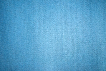 A photo of the texture of a blue felt fabric.Textile material for embroidery and needlework.Soft blue background.