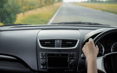 woman driver's hands are holding the steering wheel inside the car.