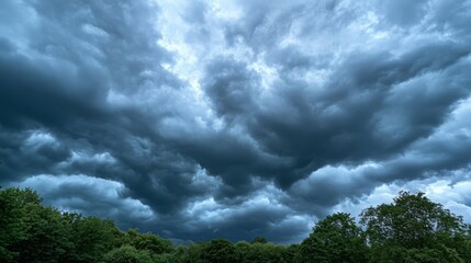 Dramatic storm clouds gathering over lush green trees, signaling an impending storm with a moody and atmospheric vibe