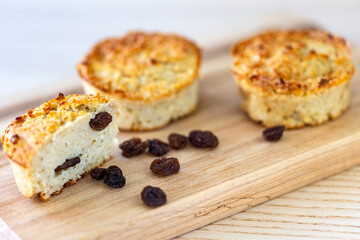 Oat, cottage cheese and raisin muffins on wooden cutting board.