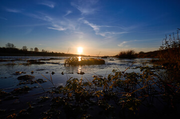 Obraz premium Beautiful Sunset by the River on a Sunny Summer Day with Stunning Bokeh Blur