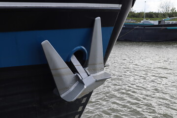 silver colored anchor hangs on the side of a boat or ship