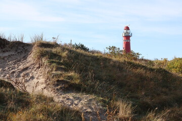 Red lighthouse on the island of Schiermonnikoog, with dunes and marram grass in the foreground