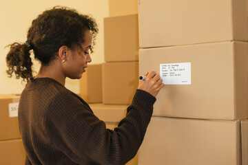 Warehouse Worker Labeling Boxes with Inventory Information