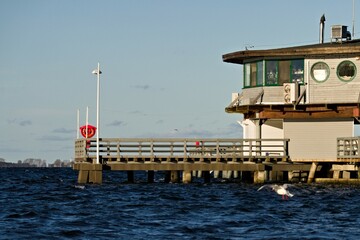 budynek na molo nad wzburzoną wodą w słoneczny dzień © Piotr