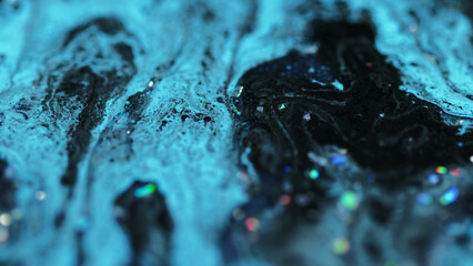 Liquid glitter texture. Ink drip. Defocused black blue color holographic sequin particles gloss paint mix oil emulsion fluid spill abstract art background.