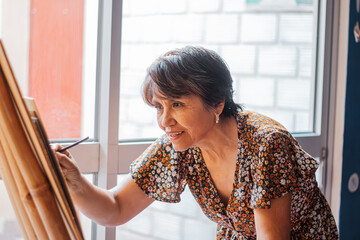 Mature woman painting with joy on a canvas