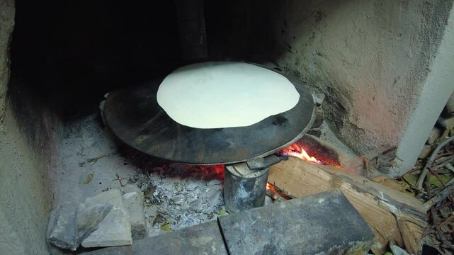 Turkish style yufka bread cooked on a baking sheet over a wood fire. 